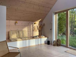 een woonkamer met een bank en een raam bij Architect-Designed House Close To Hornbæk in Tikøb