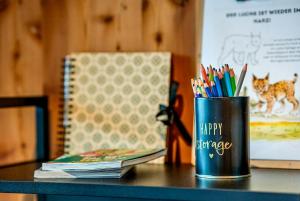 a cup of pens and pencils on a table at Treetop Loft In Harz National Park in Ilsenburg
