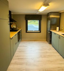 a kitchen with a wooden floor and a window at Charming Seaside Cabin With Amazing View in Hardbakke