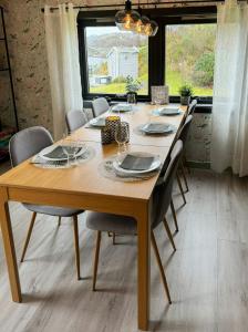 a wooden table with chairs around it in a dining room at Charming Seaside Cabin With Amazing View in Hardbakke +28 photos
