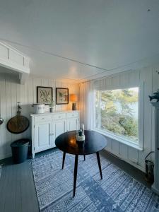un soggiorno con un tavolo e una finestra di Charming Sea Cabin On Fluer By Kragerø a Valle