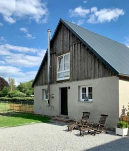 a couple of chairs sitting outside of a house at Cozy Holiday Home In The Mecklenburg Lake District in Hohen Demzin