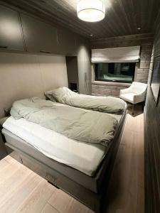 a bedroom with a bed and a chair in it at Unique Cabin With Spa And Ski In-Ski Out in Hemsedal