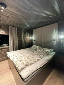 a large bed in a room with a wooden ceiling at Unique Cabin With Spa And Ski In-Ski Out in Hemsedal +27 photos