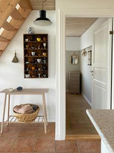 a kitchen with a table and a shelf with spices at Summer House With Panoramic View Near Doverodde in Doverodde