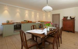 a kitchen with a wooden table with chairs and a dining room at Vacation Apartment Near The Lake in Walow +14 photos