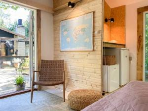 a room with a bed and a refrigerator and a chair at House In Skæring Near City And Nature in Egå