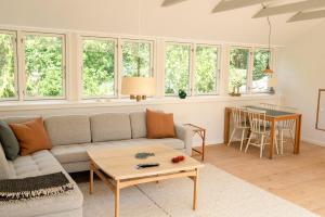 a living room with a couch and a table at Red Stone House By Dueodde Beach in Neksø