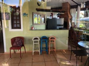 a kitchen with two stools and a counter with a counter at Chalé Aconchegante em Piracaia in Piracaia