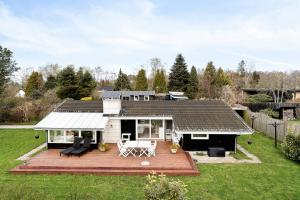 a house with a wooden deck in the yard at Bright And Cozy Cottage Close To The Sea in Hornbæk