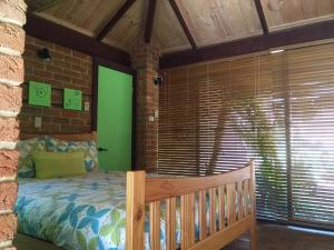 sypialnia z łóżkiem i ceglaną ścianą w obiekcie Dunsborough Ridge Retreat w mieście Dunsborough