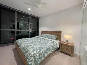 Un dormitorio con una cama y una mesita de noche con una lámpara. en Queens Wharf 54th Floor, en Brisbane