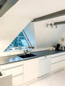 a white kitchen with a sink and a window at Summerhouse By The North Sea in Vestervig