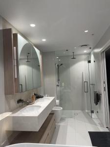 Un baño con dos lavabos, un inodoro y una ducha. en Queens Wharf 54th Floor, en Brisbane 12 fotos más