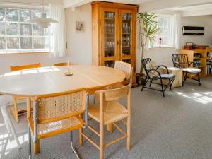 een eetkamer met een houten tafel en stoelen bij Bindingsværkshus Med Udsigt På Samsø in Nordby
