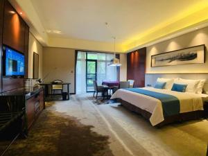 une chambre d'hôtel avec un lit et une télévision dans l'établissement Country Garden Phoenix Hotel Yiyang, à Heshanqu