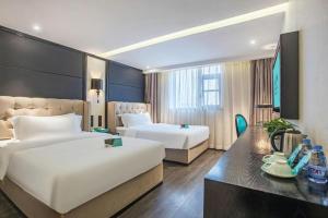 a hotel room with two beds and a desk at Xana Hotelle Nanchang Tengwang Pavilion Wanshougong in Nanchang +232 photos