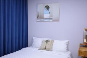 a bedroom with a blue curtain and a bed with a pillow at Aewol Bada 24 in Jeju
