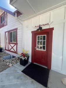 a red door on the side of a building at the Red Roof Farmhouse in Nampa