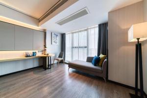 a living room with a couch and a table at Echarm Hotel Nanjing Lishui High-speed Railway Station Wuzhou Commercial City in Lishui