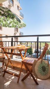 a wooden table and chairs on a balcony at Flat Lora Pomorie in Pomorie