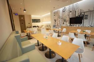 a restaurant with tables and chairs and a tv on the wall at City Comfort Inn Dong'an Avenue County Government in Guzhuting