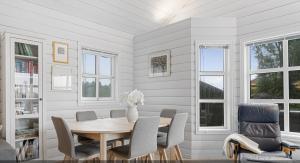 a dining room with a wooden table and chairs at Peaceful Cabin In Skrabbavikjå With Fjord View in Hervik +28 photos