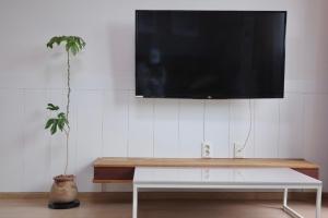 a flat screen tv hanging on a white wall at Aewol Bada 23 in Jeju