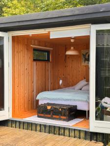 a bed is inside of a wooden house at Family Idyll Near Kattegat In Tisvilde in Tisvildeleje +12 photos