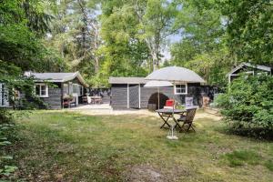 een picknicktafel met een paraplu voor een hut bij Classic 1937 Cottage On A Natural Plot in Nykøbing Sjælland