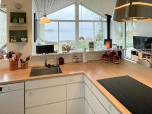 a kitchen with a sink and a counter with windows at Stunning Sunrises Over Harre Vig in Roslev