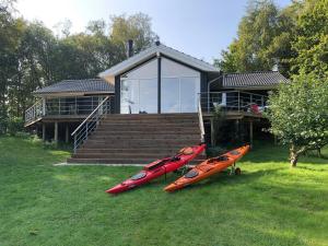three kayaks are parked in front of a house at Stunning Sunrises Over Harre Vig in Roslev +32 photos