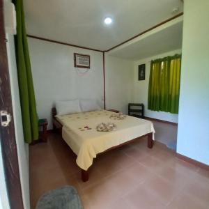a bedroom with a bed with a yellow and green curtain at Villa Evergreen Restaurant and Rooms in San Vicente +37 photos