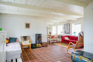 a living room with a couch and a fireplace at Cut Branches, Make Fire And Gaze At Treetops in Nykøbing Mors