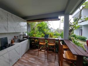 an outdoor kitchen with a wooden table and chairs at PUSPA guest house in Canggu
