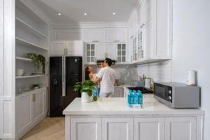 a man standing in a kitchen with a refrigerator at The Salt Villas Da Nang - 250sm 3BR, 4BA & Kitchen in Danang