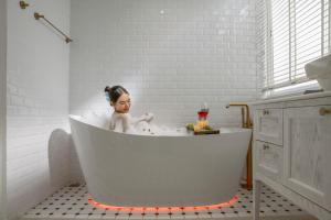 a little girl sitting in a bath tub at The Salt Villas Da Nang - 250sm 3BR, 4BA & Kitchen in Danang +55 photos