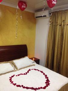 Una cama con un corazón hecho de flores. en I BBBSAI Casa Vacacional en San Andres Islas – Alquiler, en San Andrés