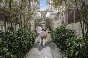 a family walking through a garden at The Salt Villas Da Nang - 250sm 3BR, 4BA & Kitchen in Danang
