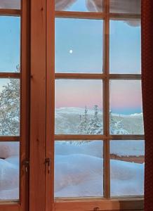 a window with a view of a snow covered field at Family Fun Cabin In Engerdals Heart in Nymoen