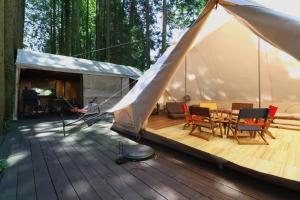 a tent with a table and chairs on a wooden deck at 南阿蘇 StayHappy in Minami Aso