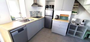 a small kitchen with a sink and a refrigerator at Gîte AnjouLoire in Saint-Mathurin