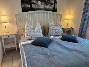 a bedroom with a bed with blue sheets and pillows at Toms Stuga Ferienwohnung in Schöneiche