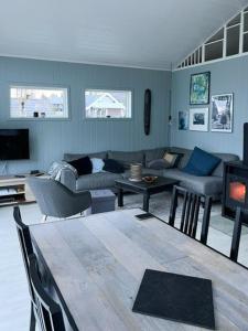 a living room with a couch and a table at Charming Cabin With Archipelago Views In Sogn in Ånneland