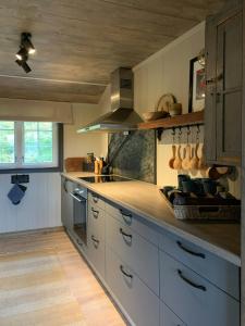 cocina con armarios blancos y techo de madera en Secluded Mountain Cabin In Rauland With View, en Rauland