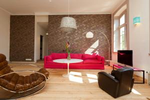 a living room with a red couch and a table at Spacious Apartment With Terrace And Garden View in Walow