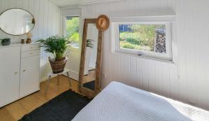 a bedroom with a bed and a mirror and a window at Home Near Juelsminde By The Beach in Sønderby
