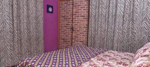 una habitación con una cama y una pared de ladrillo en Apartment at Clifton Block VIII, en Karachi