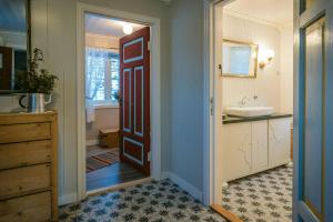 ein Bad mit einem Waschbecken und einer Tür zum Bad in der Unterkunft Family-Friendly Cabin With Agricultural Idyll in Vestre Gausdal + 24 Fotos