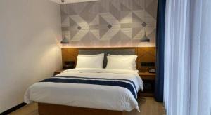 Postel nebo postele na pokoji v ubytování Borrman Hotel Shaoguan Nanxiong Rt-Mart